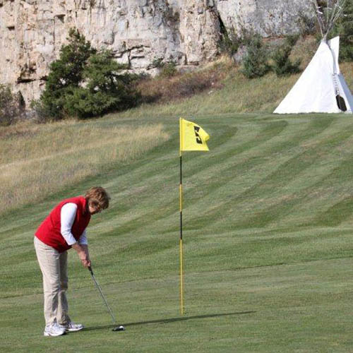 Golfing with tipi in background in Central Montana