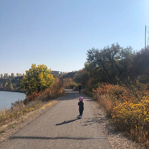 Child using scooters on Rivers Edge Trail